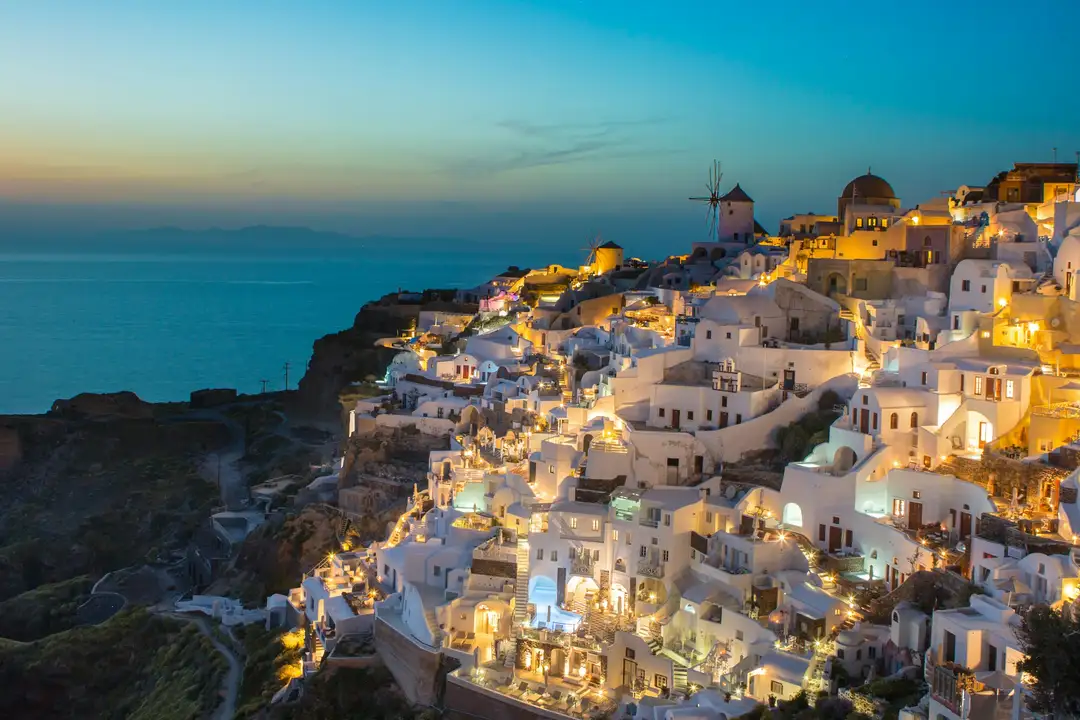 Oia, en Santorini, iluminada al anochecer sobre la caldera